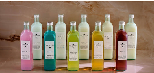 Row of colorful bottles with labels on a wooden surface